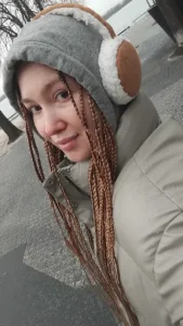 Braids on a woman in a winter coat outside with ear muffs